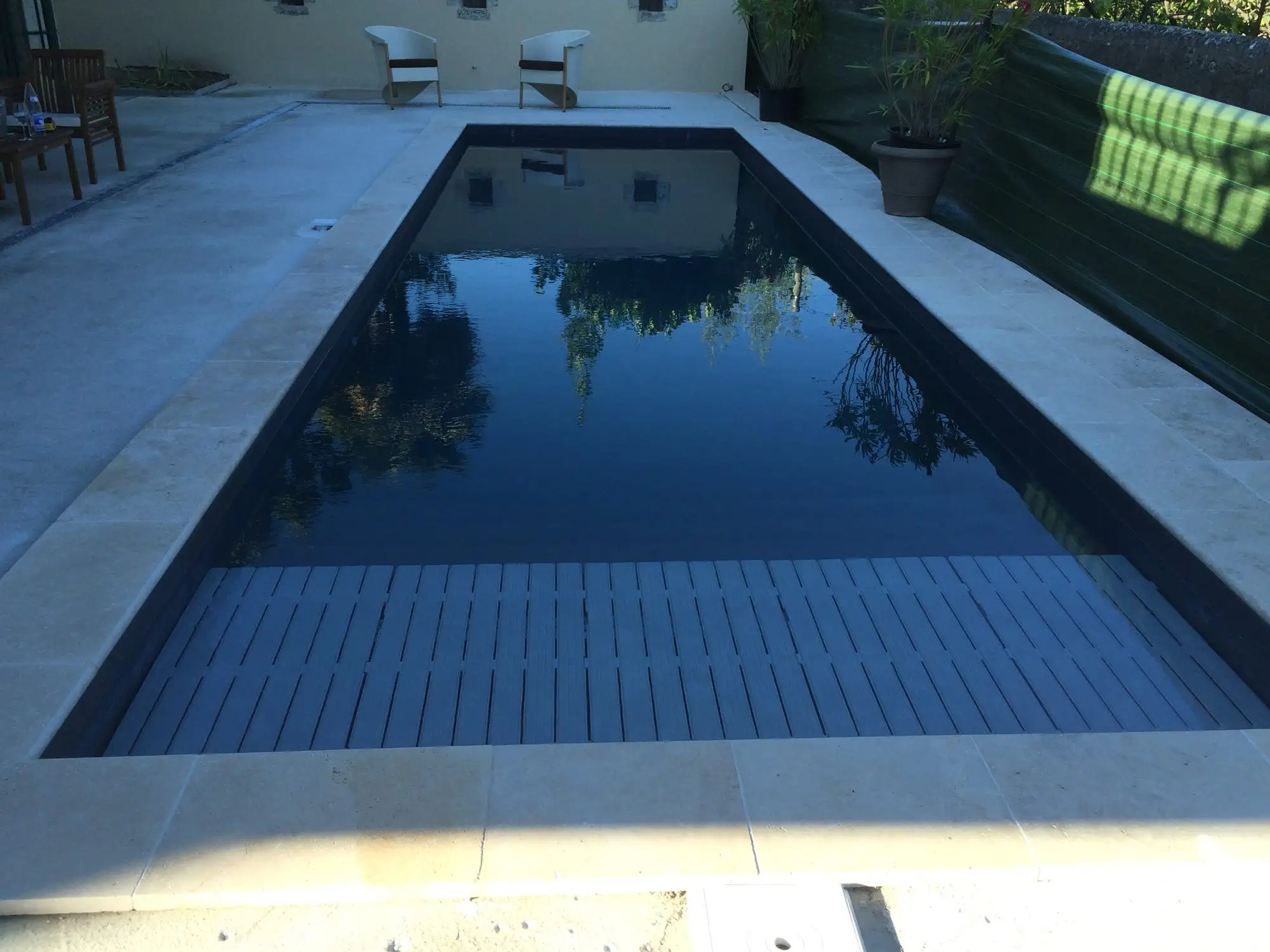 Piscine au revêtement sombre et plage claire à Aubenas