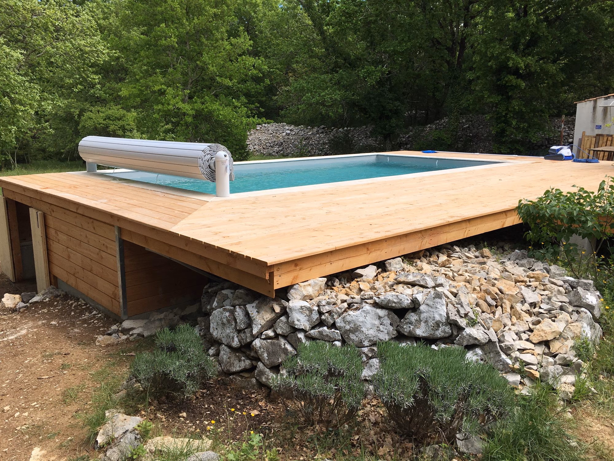 Piscine sur terrasse en pin au milieu des rochers à Balazuc