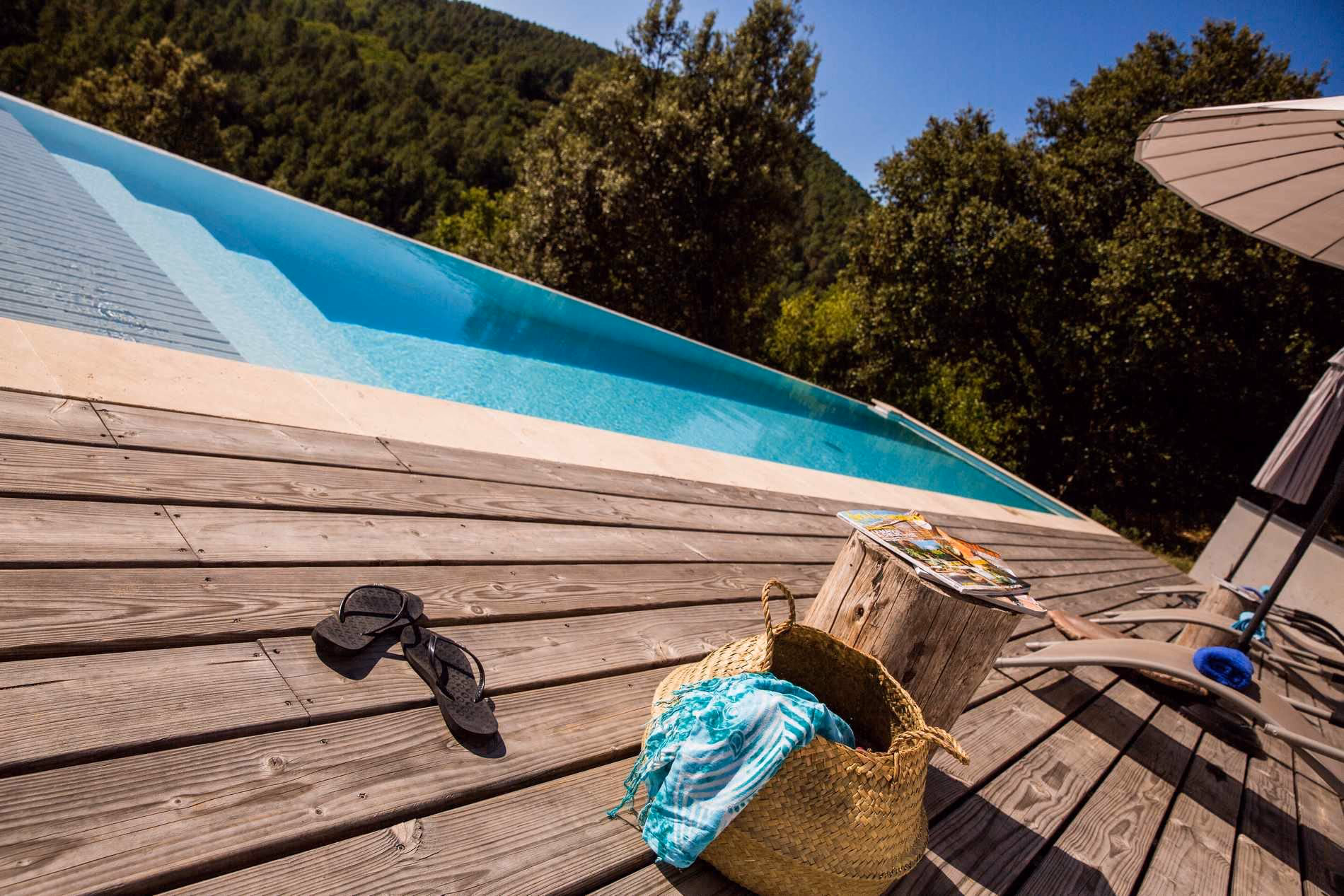 Terrasse en bois le long du débordement, face aux collines boisées de Chassiers