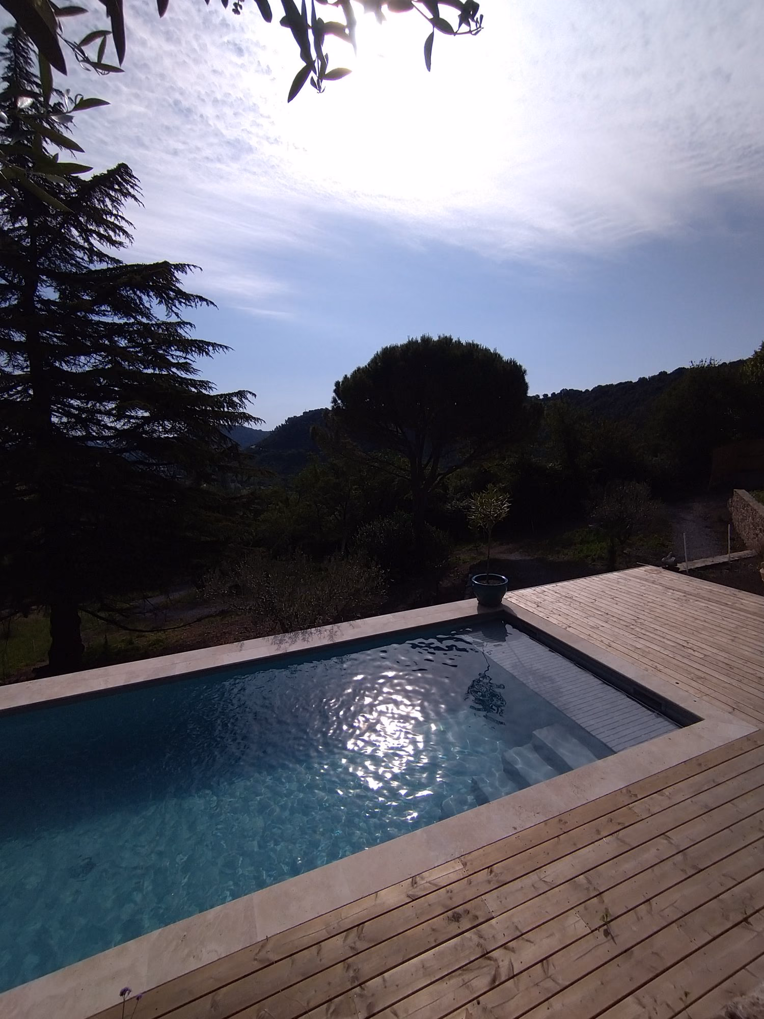 Terrasse bois et escalier d'angle d'une piscine aux Vans