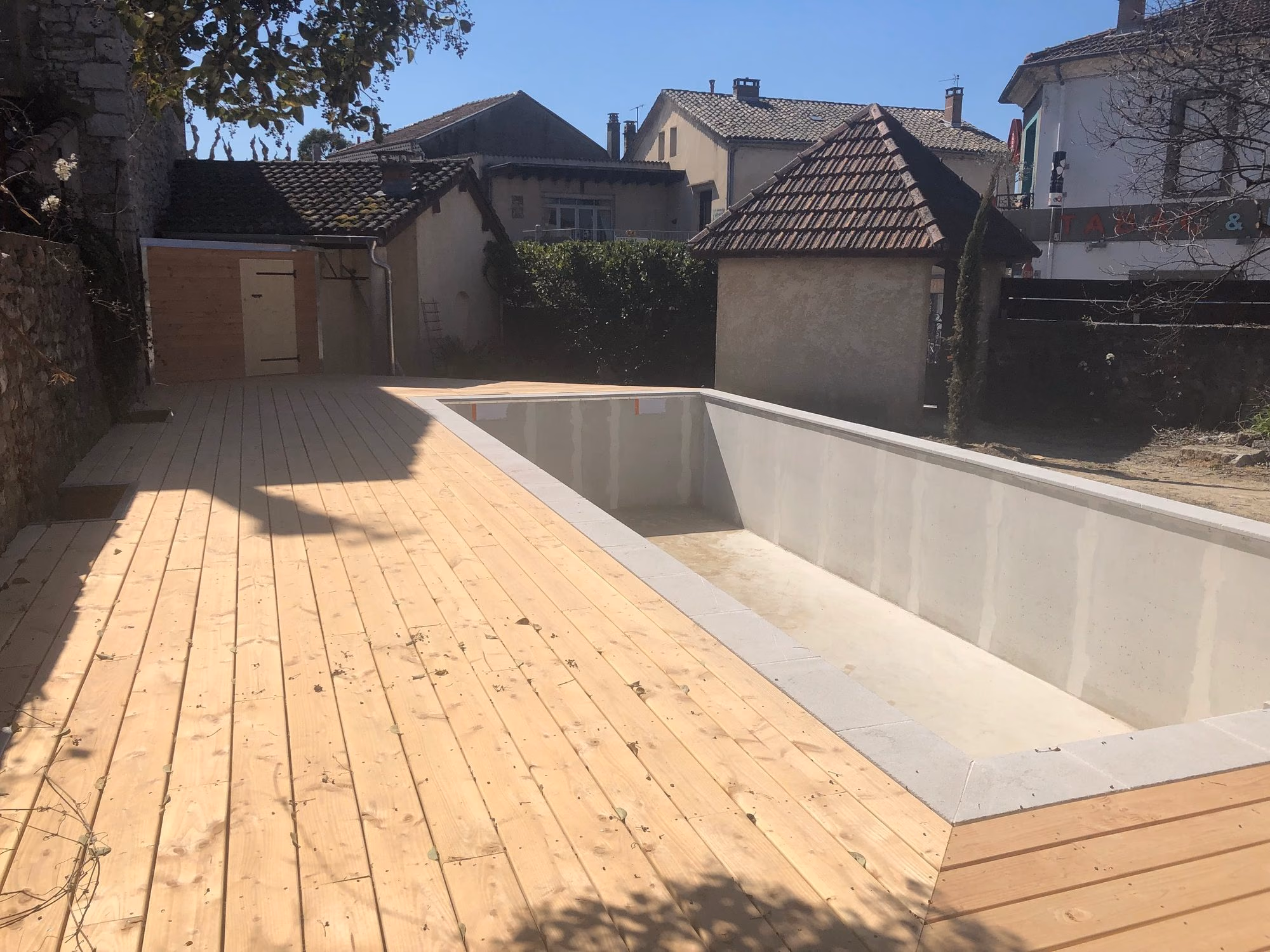 Bassin et terrasse bois dans une cour de village à Ruoms