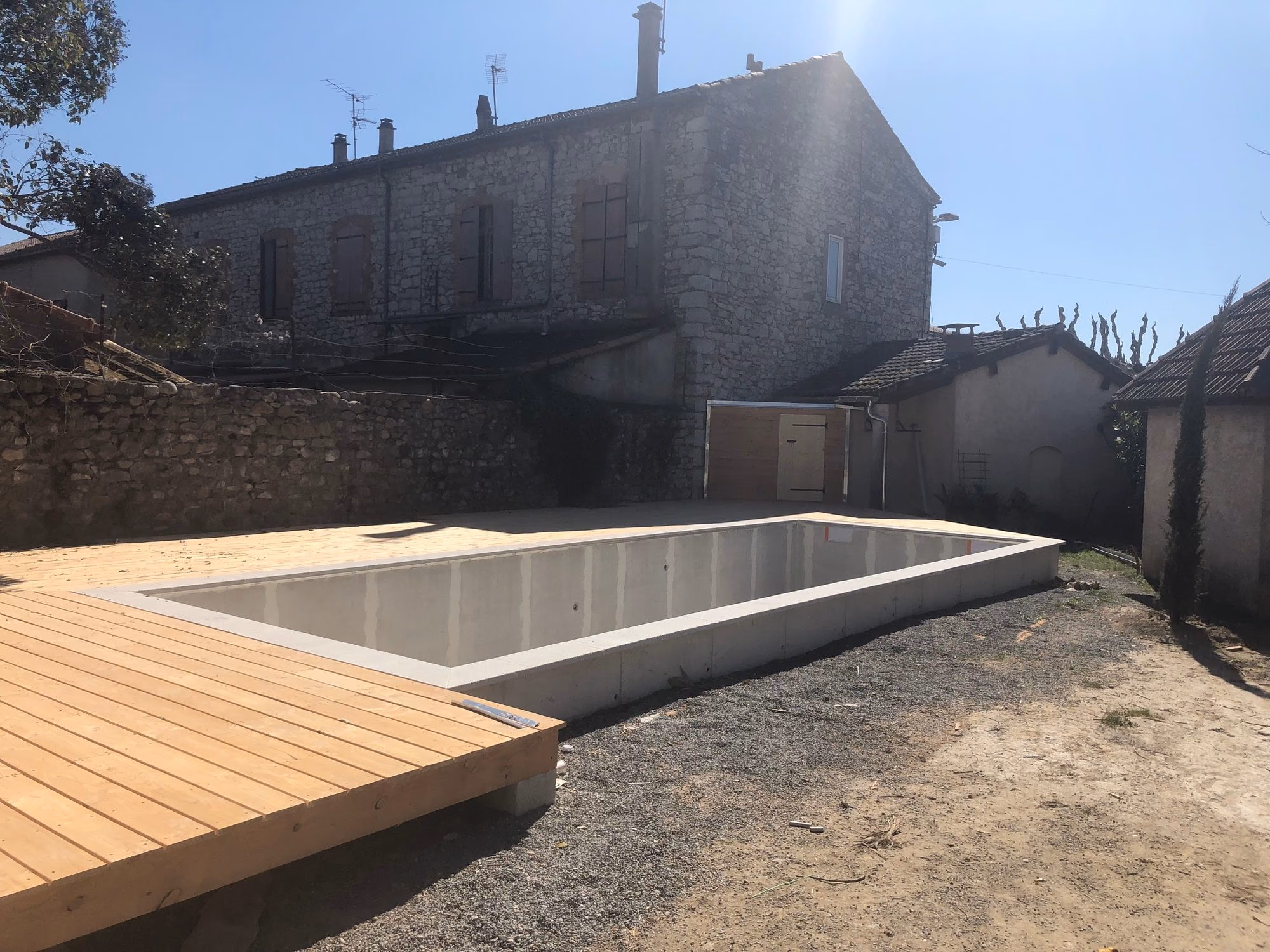 Terrasse bois autour d'un bassin vide à Ruoms