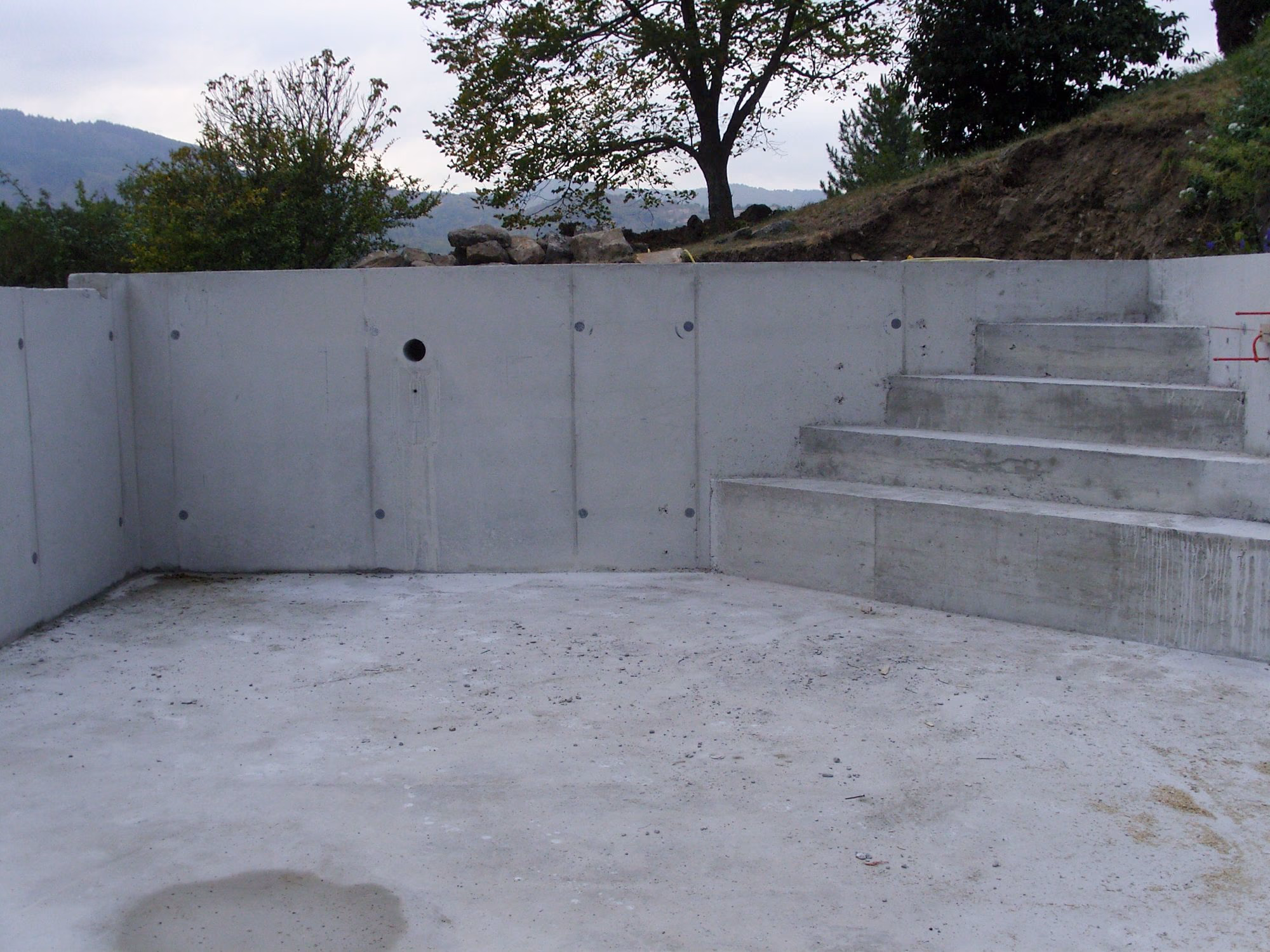 Escalier maçonné dans l'angle du bassin décoffré à Aubenas