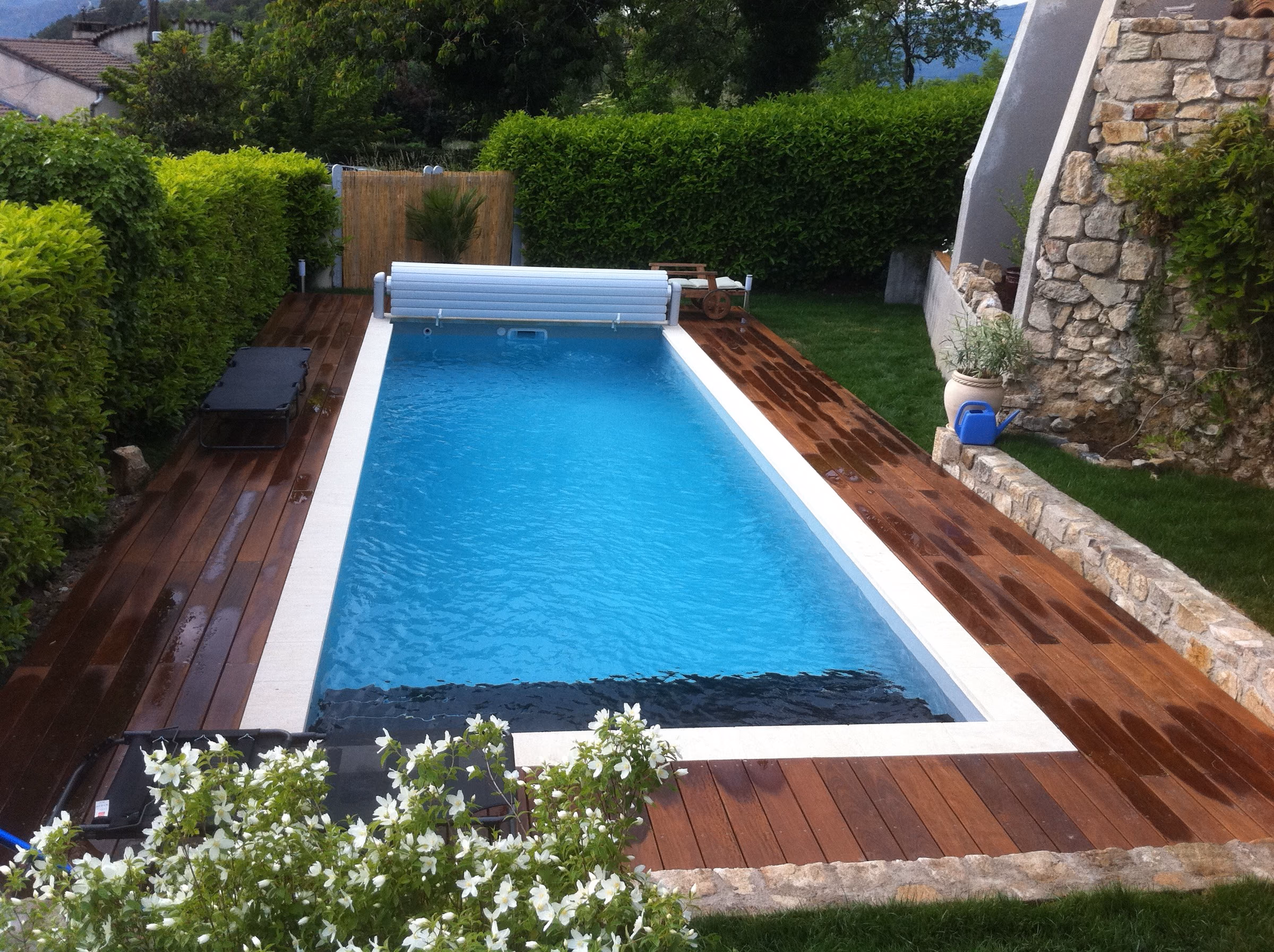 Piscine fermée par son volet, terrasse en bois