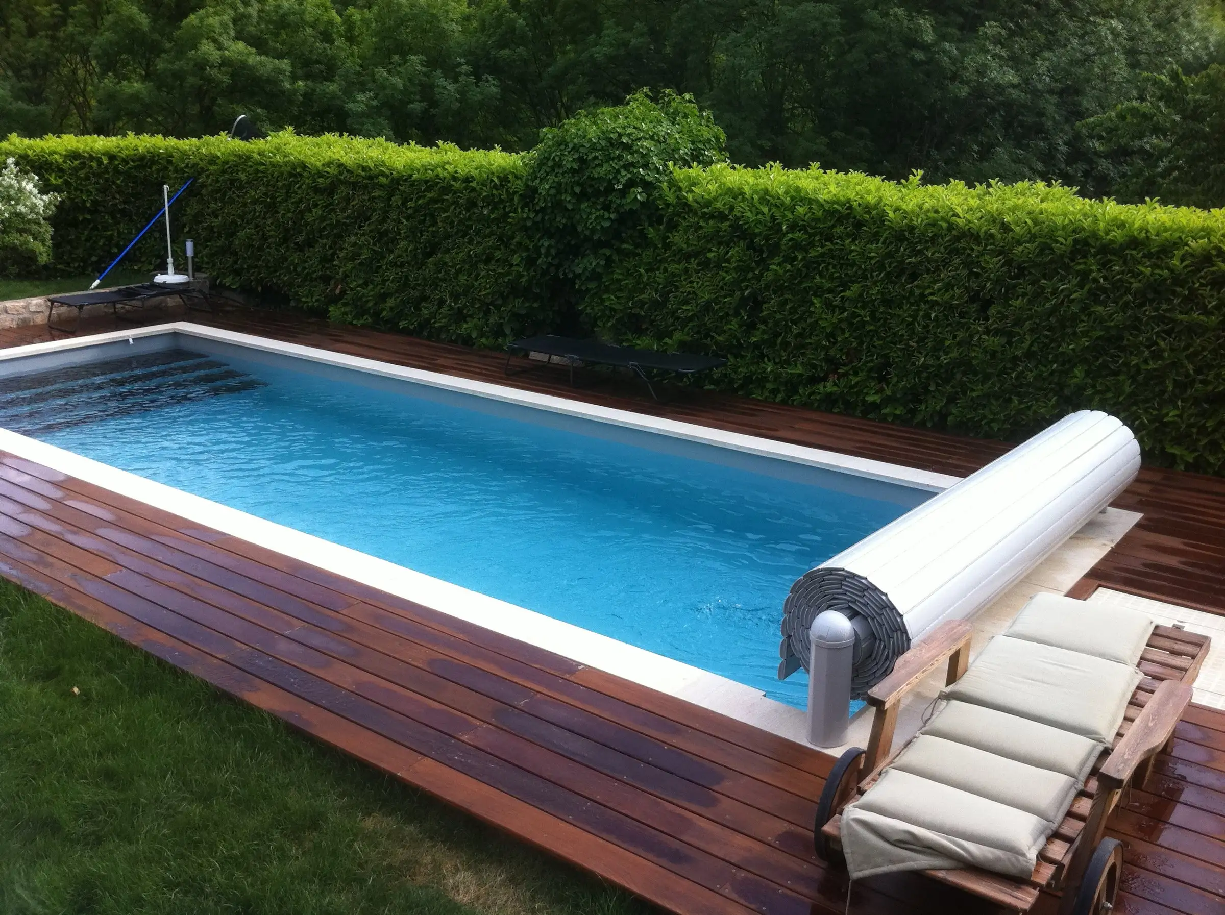 Piscine entretenue près d'Aubenas : eau claire, escalier sur la largeur et terrasse en bois