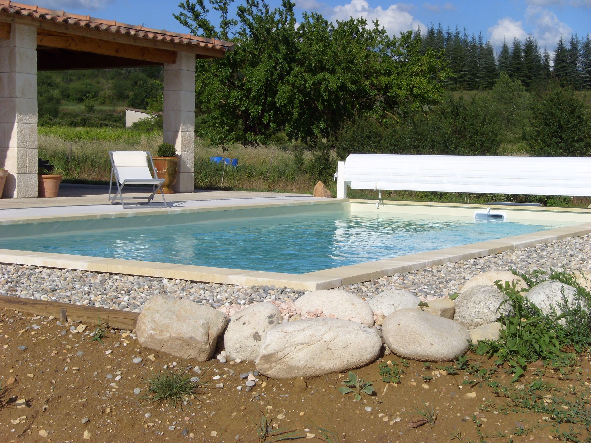 Piscine entretenue en bordure d'un jardin en pierres sèches, eau claire