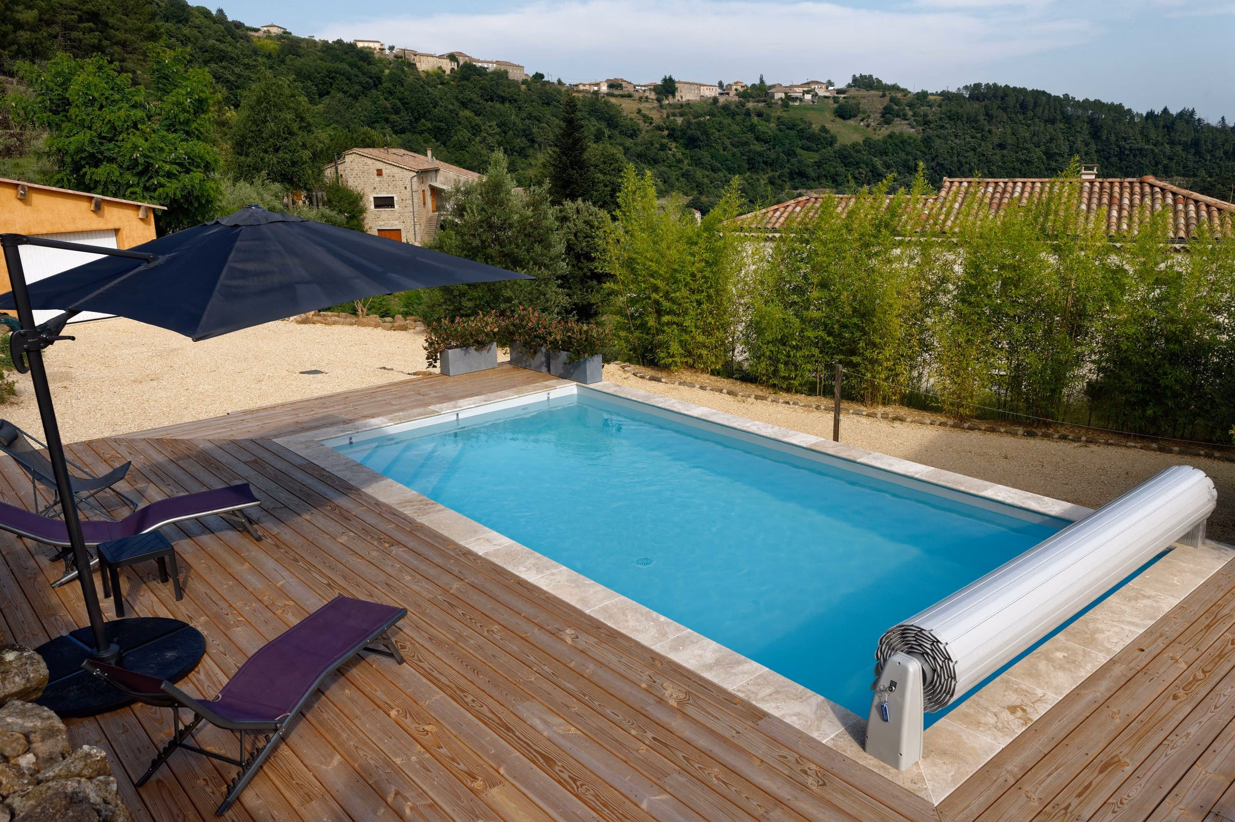 Piscine et terrasse en bois installées en surplomb des collines, en sud Ardèche