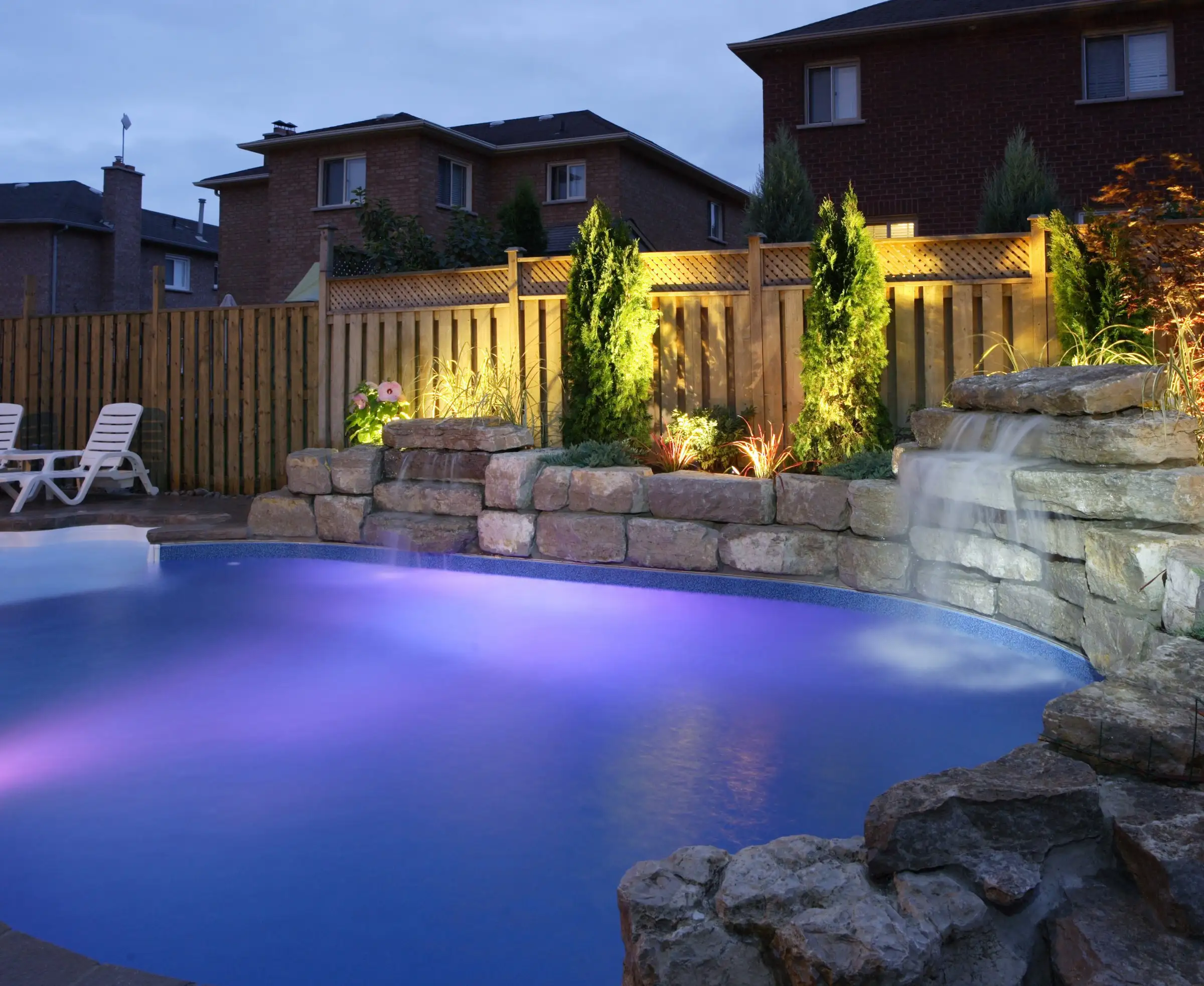Traitement et éclairage : piscine éclairée de nuit par des projecteurs LED, rocaille et cascade