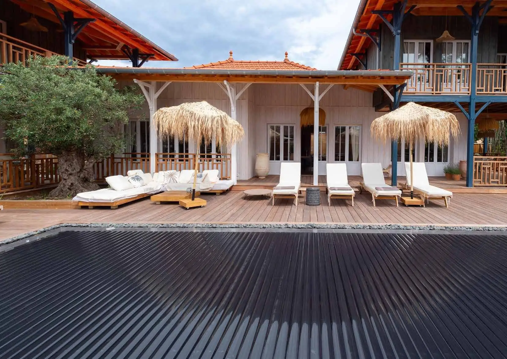 Volets et couvertures : volet immergé Abriblue à lames sombres, terrasse en bois