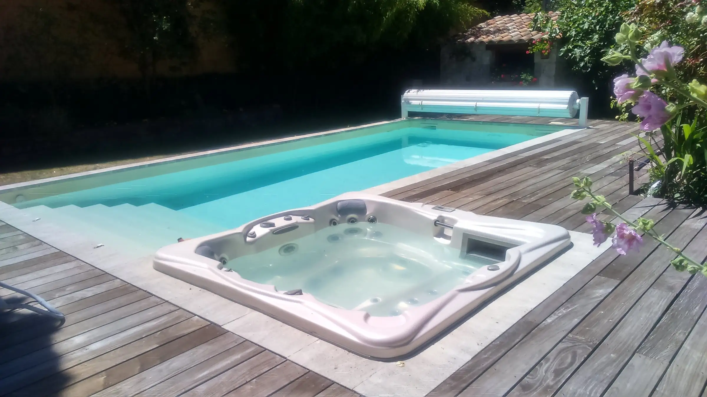 Spa et piscine côte à côte sur une terrasse en bois