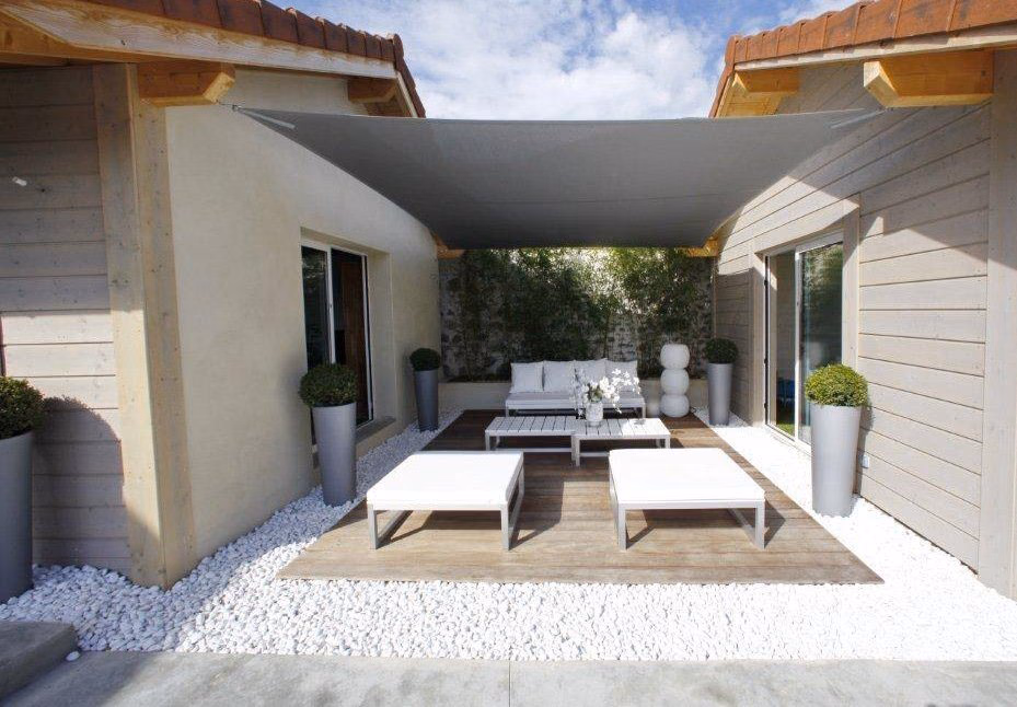 Voile d’ombrage Albigès LOV Protect tendue au-dessus d’un salon de jardin