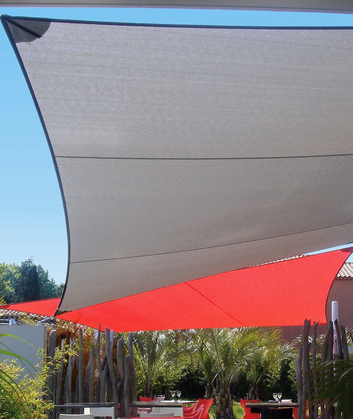 Voiles d’ombrage Albigès LOV Textil grise et rouge au-dessus d’une terrasse